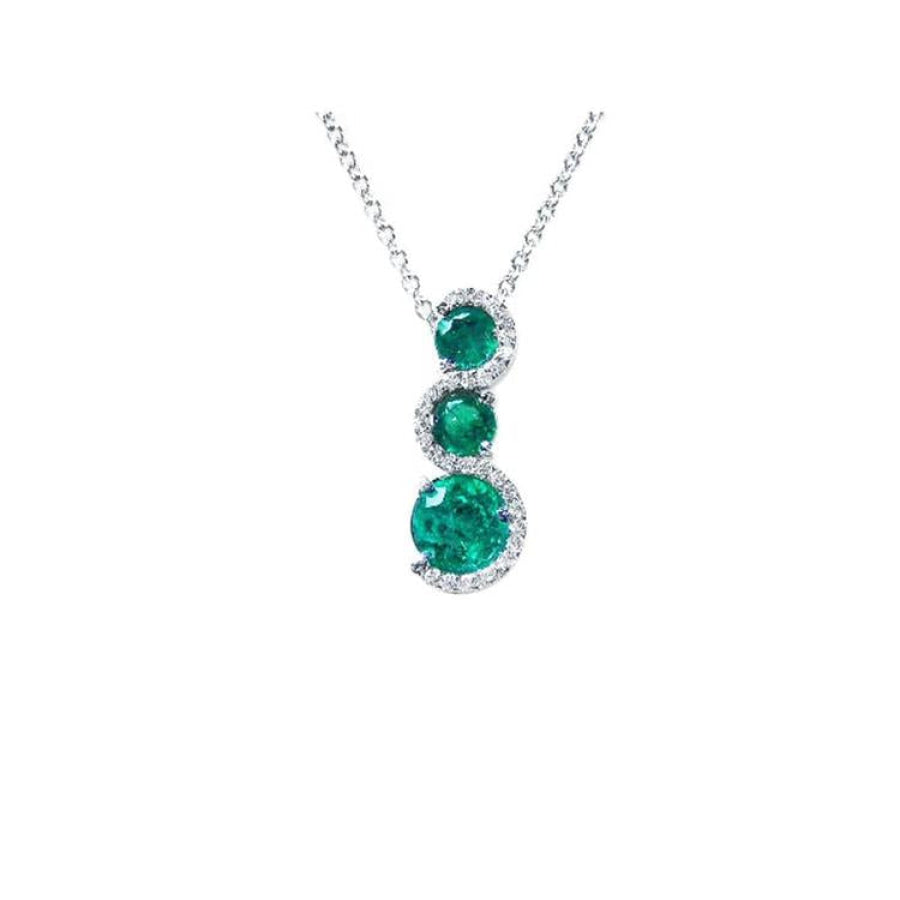 14K white gold emerald journey pendant necklace with three round, deep green emeralds encircled by diamonds.