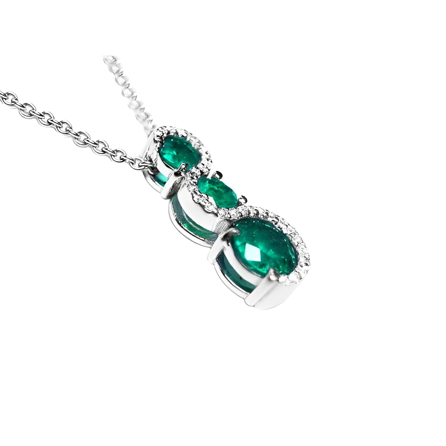 14K white gold emerald journey pendant with three round-cut Colombian emeralds and diamond accents.