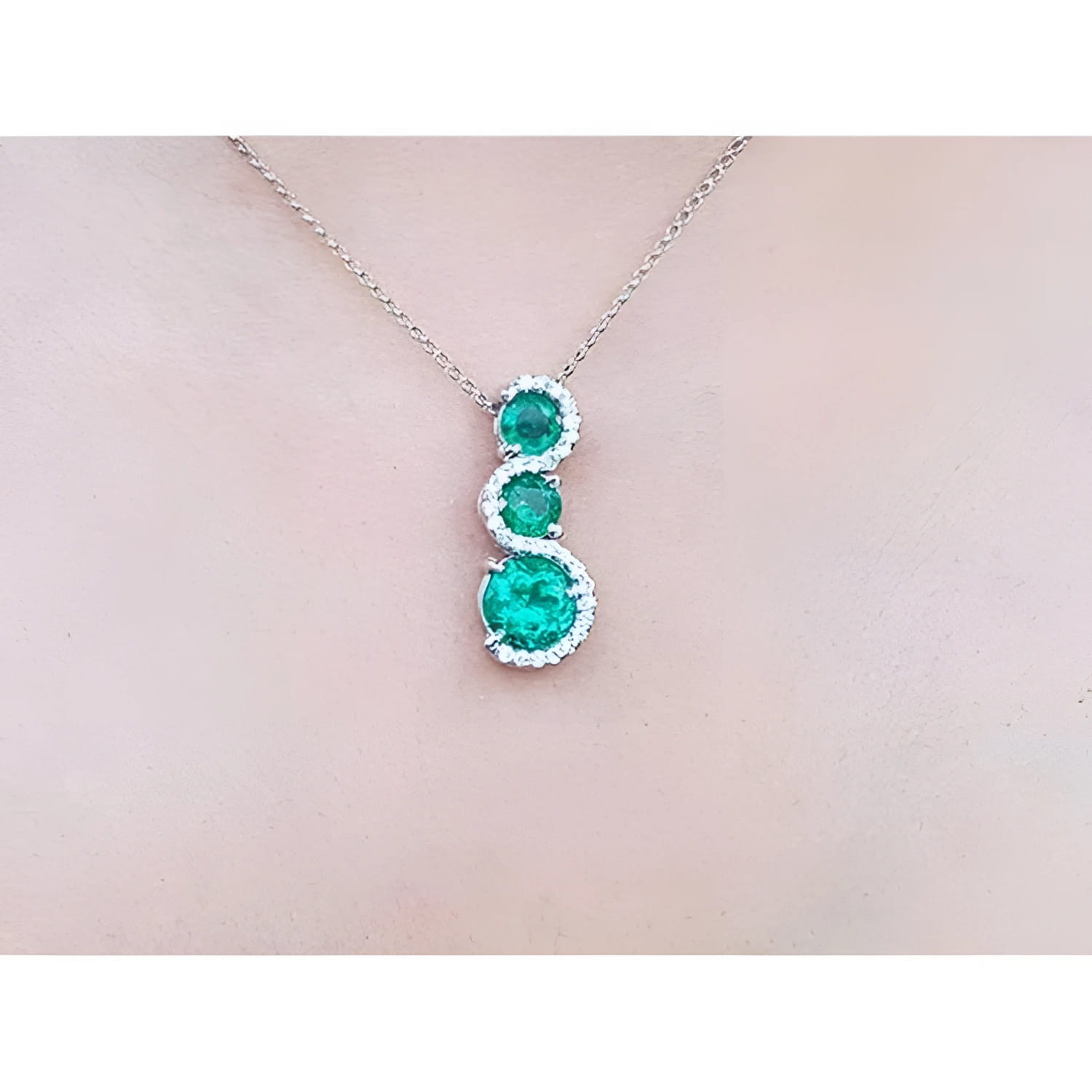 1.99 ct. emerald journey pendant necklace with three round Colombian emeralds and diamonds on a 14K gold chain.