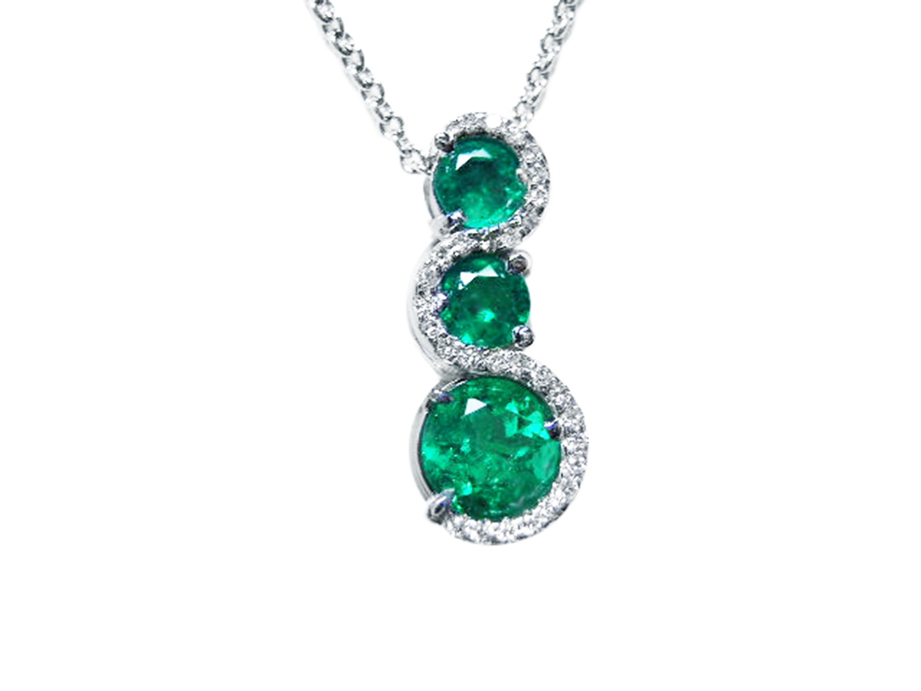 Three round cut natural colombian emerald pendant journey necklace with white gold chain on a topside view position.