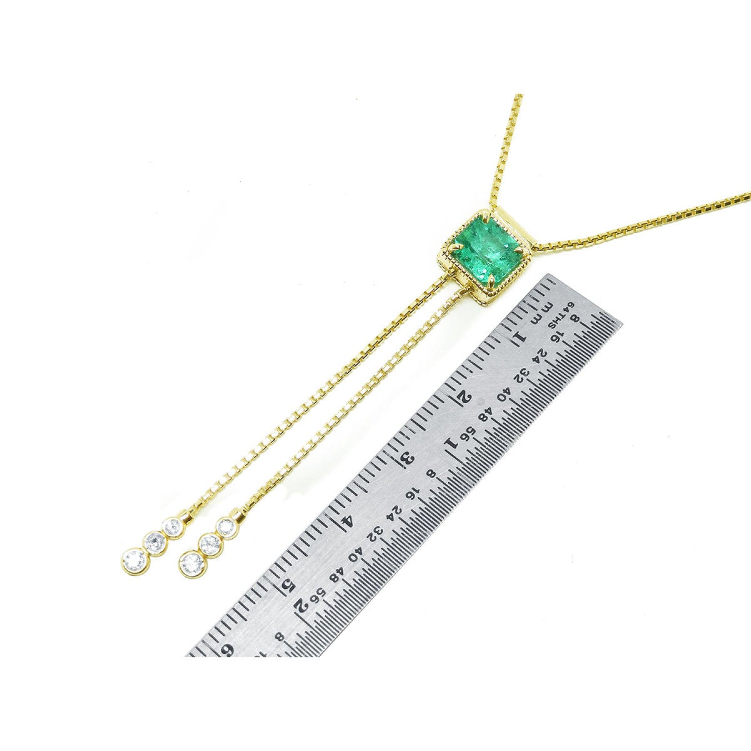 Emerald lariat necklace with an emerald-cut natural emerald, milgrain, and prong-set diamonds on a gold box chain.