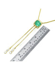 Emerald lariat necklace with an emerald-cut natural emerald, milgrain, and prong-set diamonds on a gold box chain.