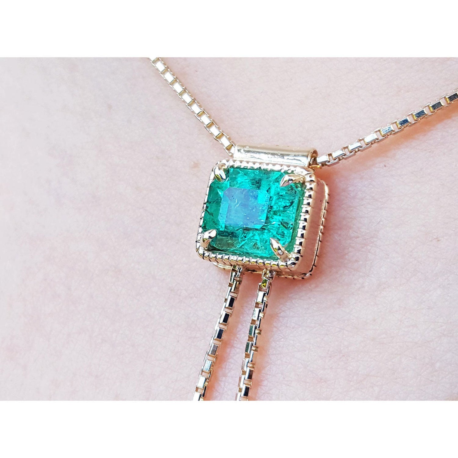 Emerald-cut natural Muzo Colombia emerald lariat necklace in 14K gold with milgrain detail on a box chain.