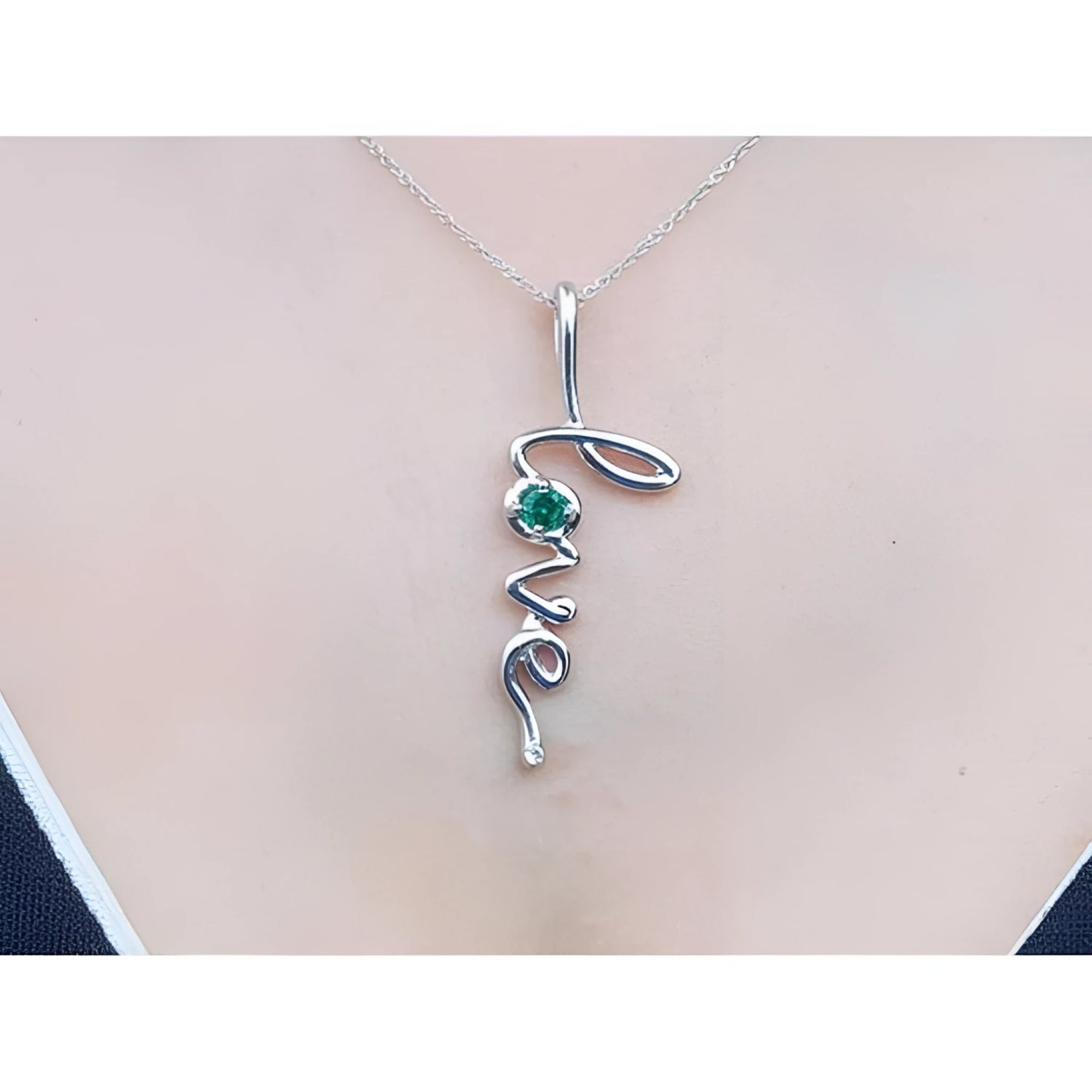14K white gold "Love" script pendant necklace with a round cut Colombian emerald.