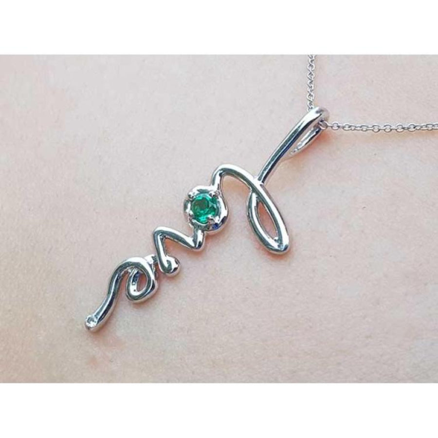 14K white gold "love" script pendant with a round Colombian emerald, on a delicate chain.