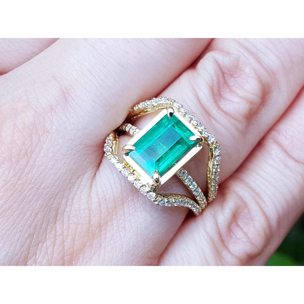 An emrald-cut emerald ring for women on a hand.