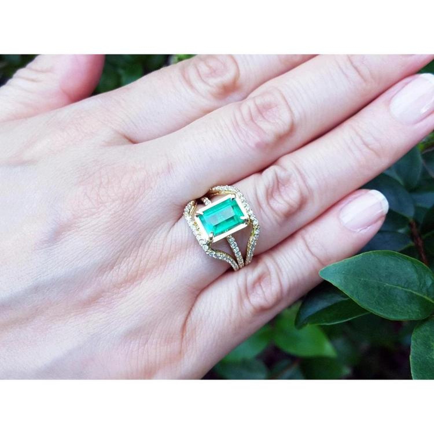 Emerald engagement ring, 2.86 ct. green emerald in 18K yellow gold with three rows of diamonds.