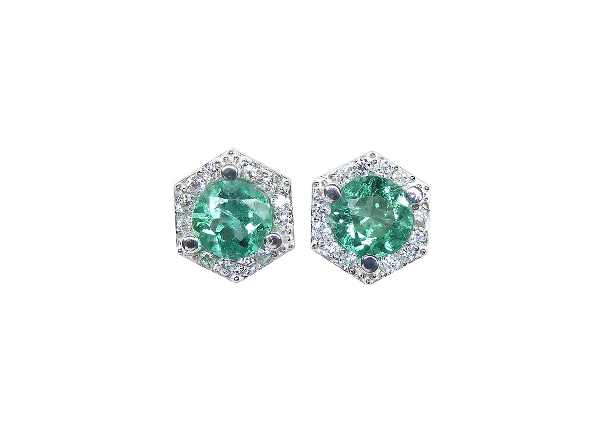A pair of emerald stud earrings with small geometric halo diamond accents, set in 14K white gold.