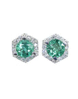A pair of emerald stud earrings with small geometric halo diamond accents, set in 14K white gold.