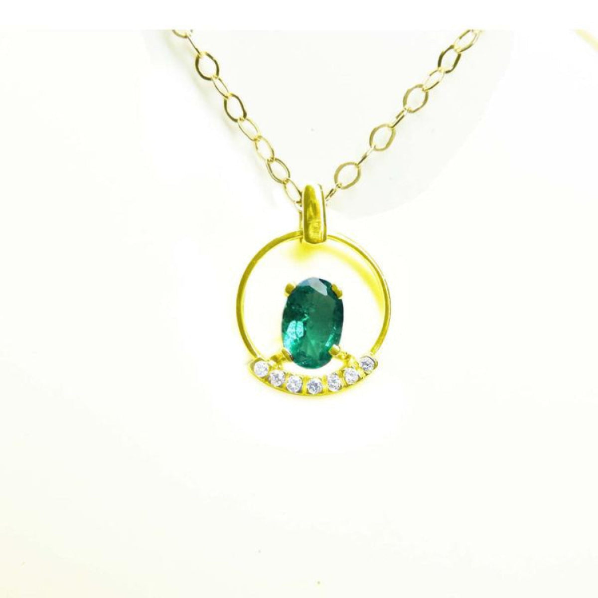 14k yellow gold necklace with oval Colombian emerald pendant and diamond accents.
