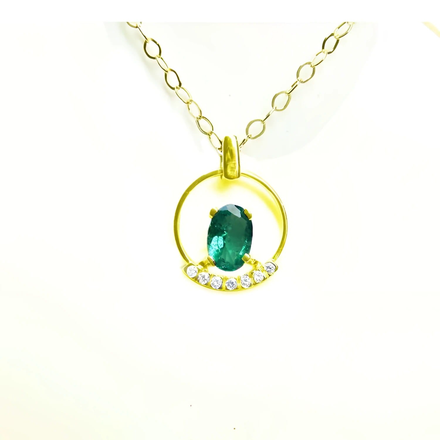 14k yellow gold necklace with oval Colombian emerald pendant and diamond accents.