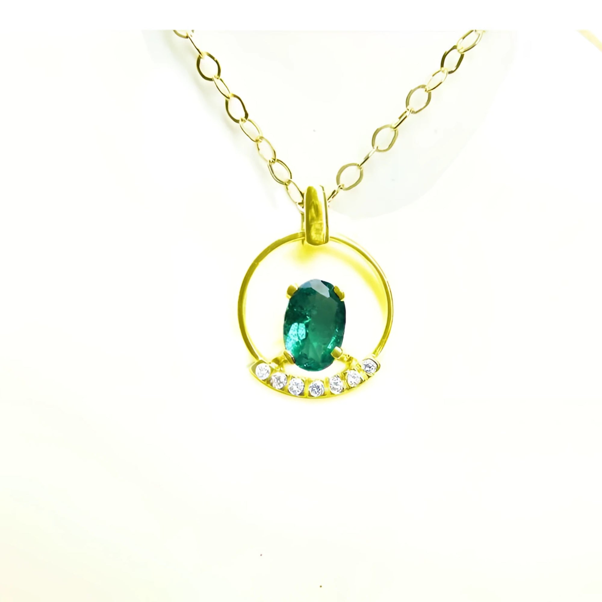 14k yellow gold necklace with oval Colombian emerald pendant and diamond accents.