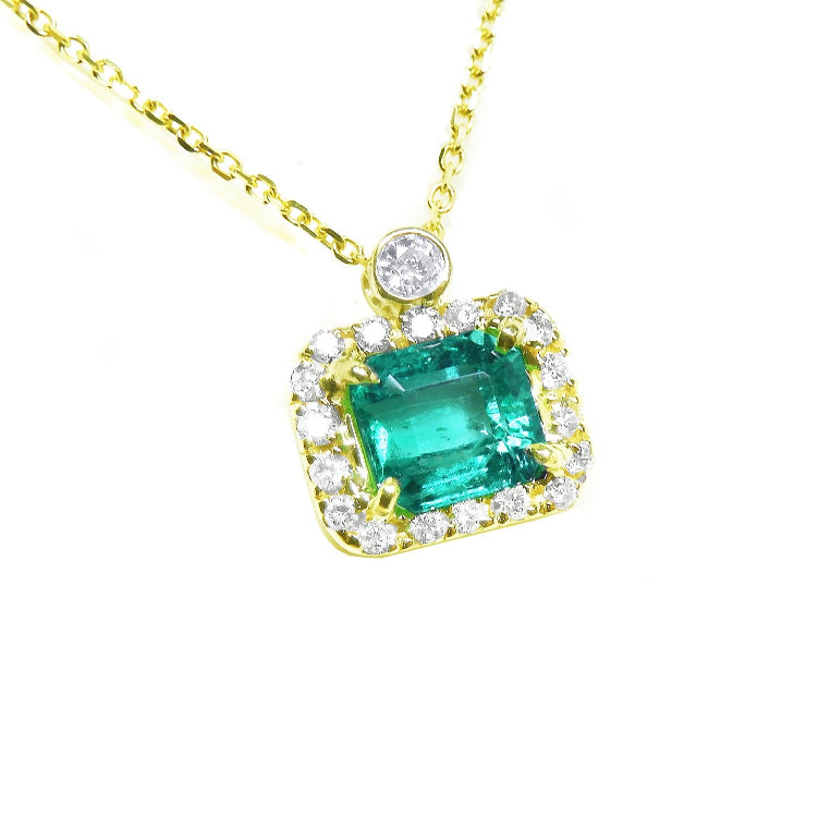 Emerald jewelry necklace east west orientation encircled in a halo of natural diamonds, crafted in 14k yellow gold