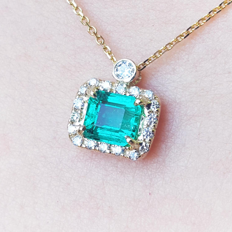 Real emerald necklace for sale east west orientation encircled in a halo of natural diamonds, crafted in 14k yellow gold