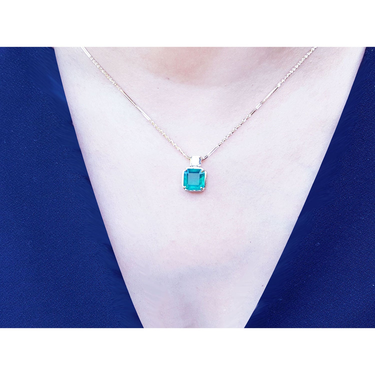 Asscher cut Colombian emerald necklace with a princess cut diamond on an 18K yellow gold chain.