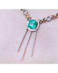 14K white and yellow gold Kisses and Hugs necklace with a square emerald and three dangling chains.