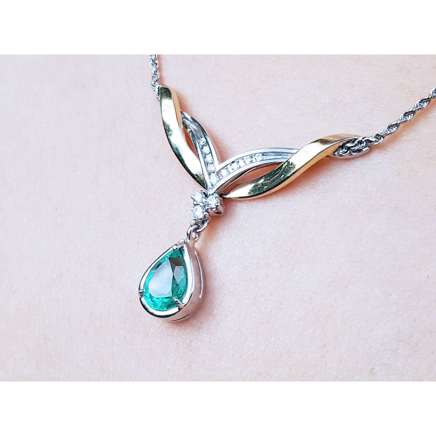 14K white/yellow gold necklace with a deep bluish-green pear-shaped emerald and diamonds.