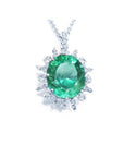 Oval cut medium light green emerald pendant with diamond halo in 14K white gold.