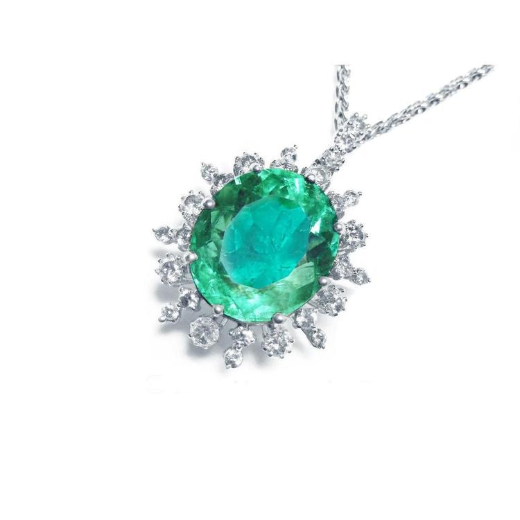 Emerald pendant with halo diamond accents on a white gold chain topside visible