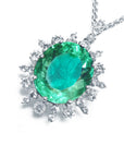 Emerald pendant with halo diamond accents on a white gold chain topside visible