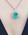 Emerald pendant necklace on a person's neck against a black background