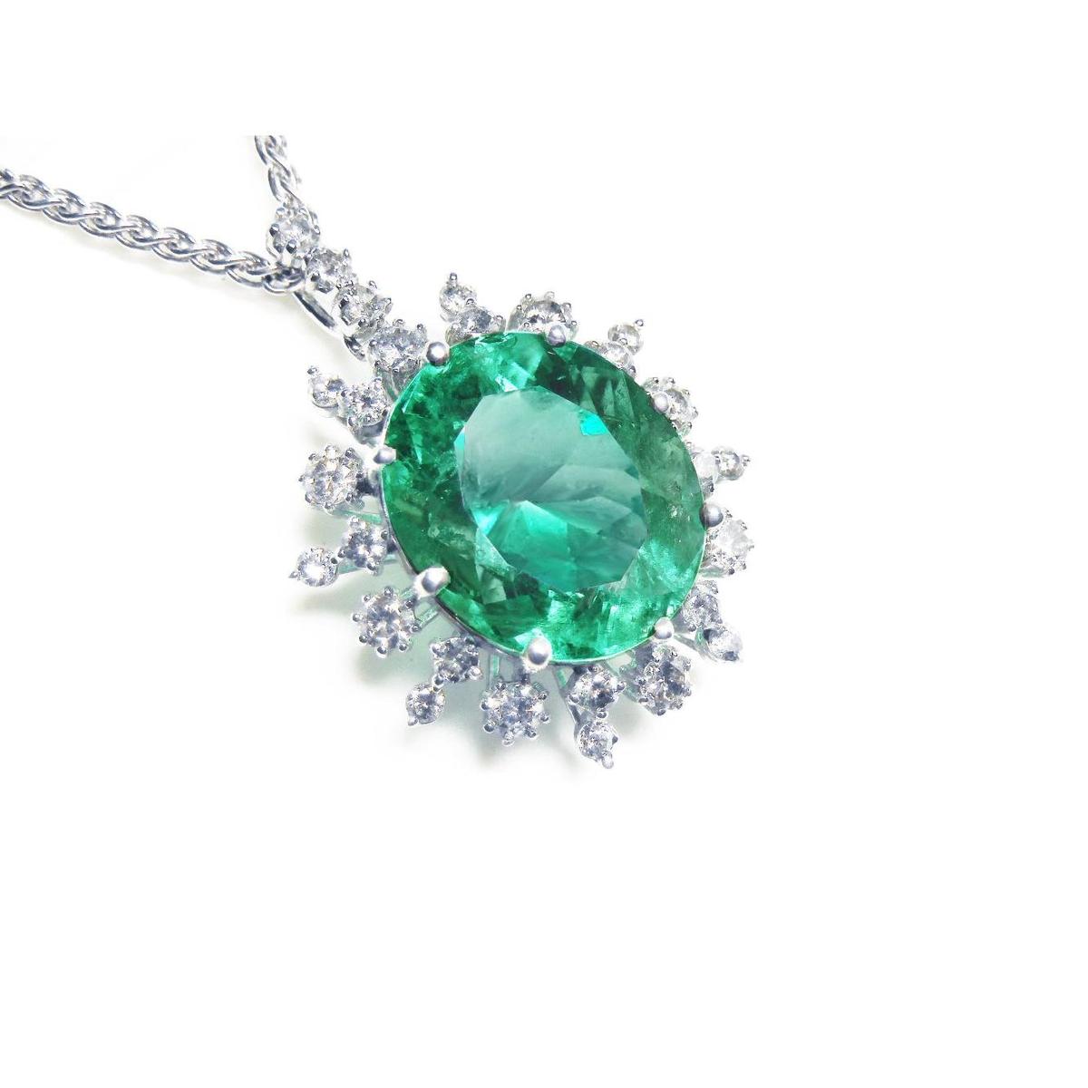 Emerald pendant with halo diamond accents in white gold on a topside position.