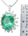 Emerald pendant with diamonds accent next to a ruler for size reference.