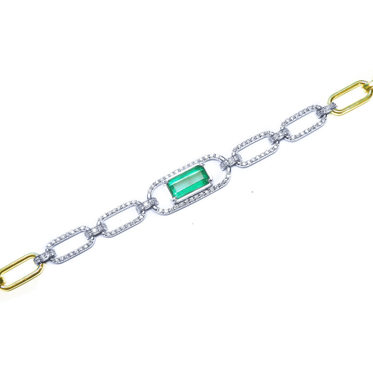 A white gold paperclip bracelet with emerald and diamonds at center and gold accents top view.