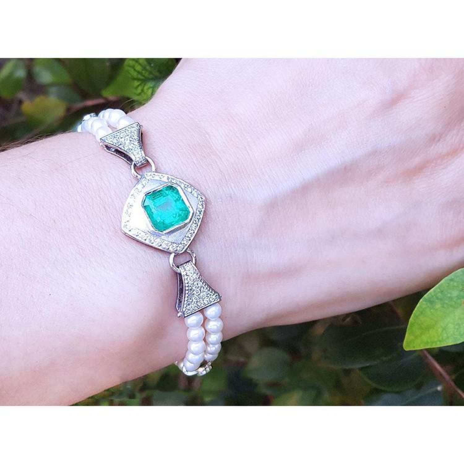 18K white gold bracelet with a bezel-set Colombian emerald, diamonds, and double strands of pearls.