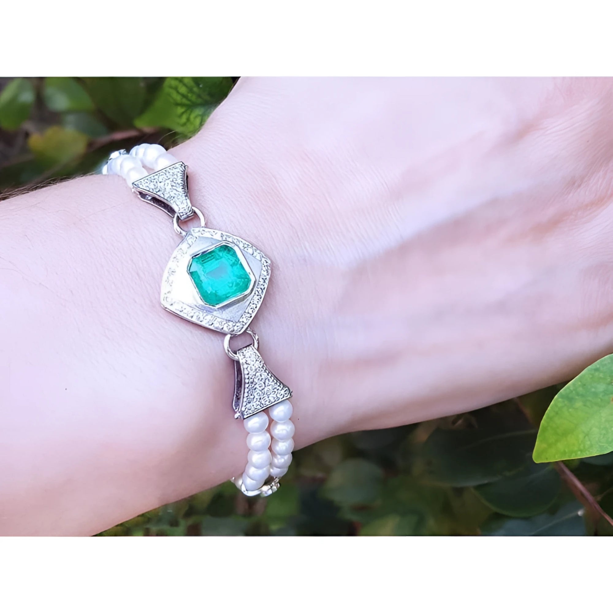 18K white gold bracelet with a bezel-set Colombian emerald, diamonds, and double strands of pearls.