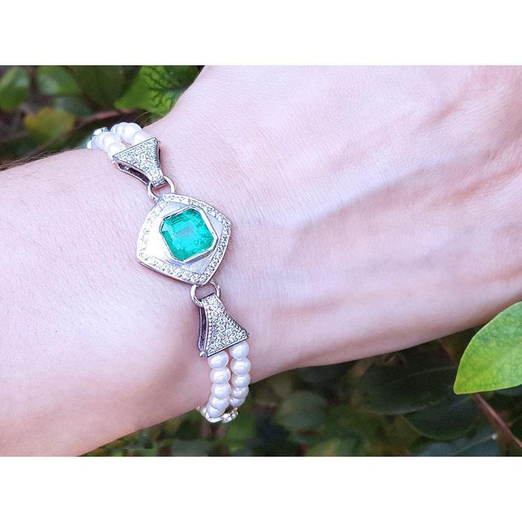 18K white gold bracelet with a bezel-set Colombian emerald, diamonds, and double strands of pearls.