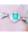 Emerald-cut Colombian emerald and pearls bracelet crafted in 18k white gold on a wrist.