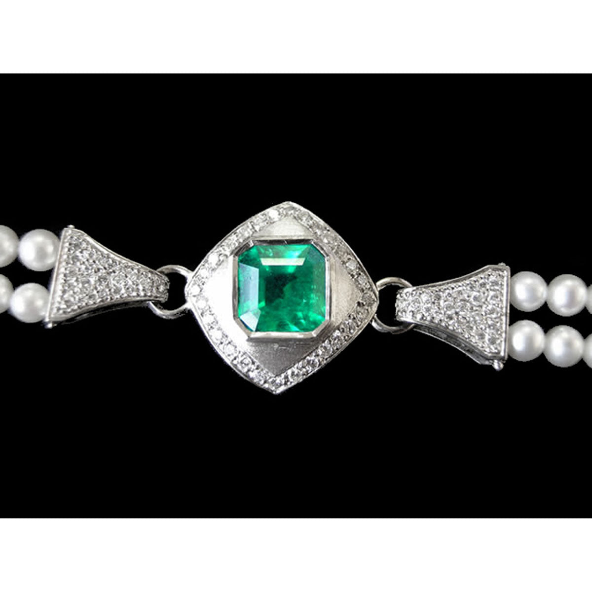 Pearl bracelet with a central emerald stone and white gold clasp on a black background.
