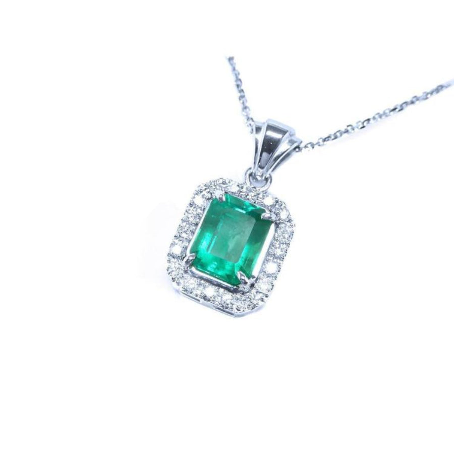Emerald-cut Colombian emerald pendant with halo diamonds in 14K white gold.