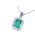 Emerald-cut Colombian emerald pendant with halo diamonds in 14K white gold.