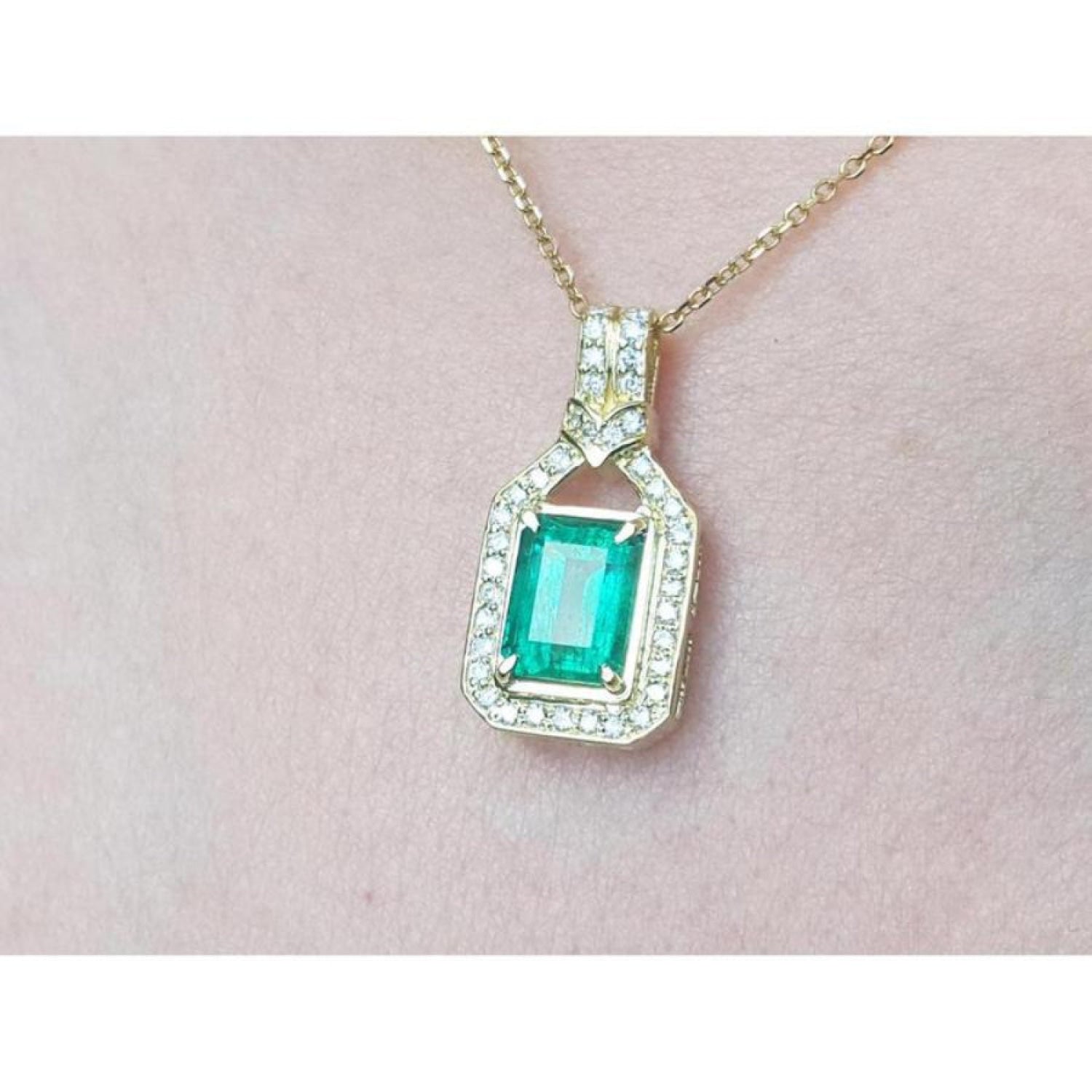 2.06 ct. emerald pendant with natural diamonds in 18K yellow gold, worn on a woman's neck.