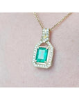 2.06 ct. emerald pendant with natural diamonds in 18K yellow gold, worn on a woman's neck.