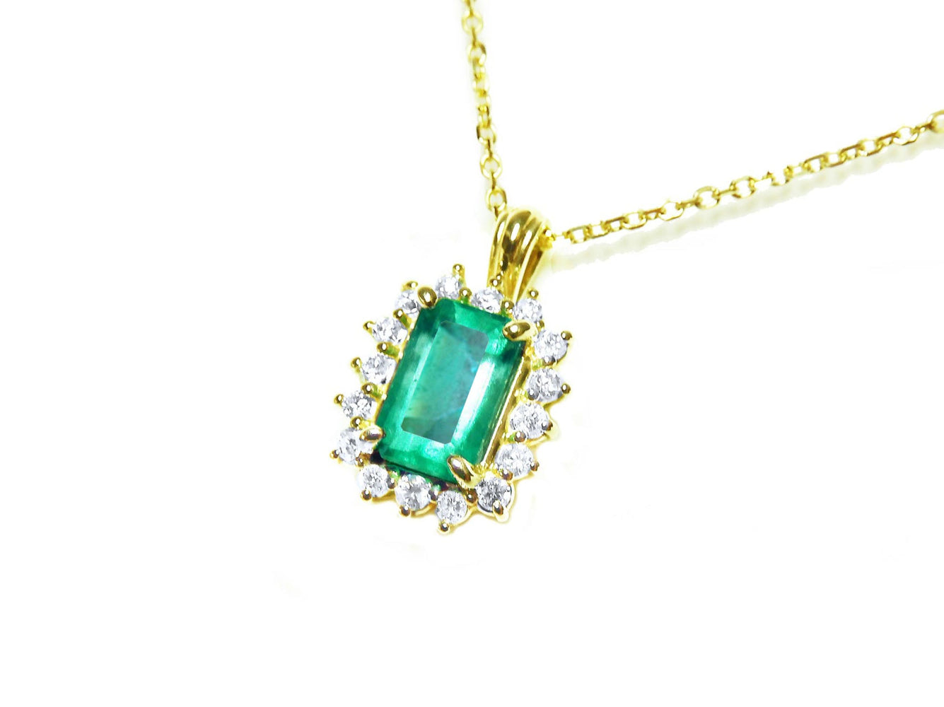 Gold necklace with a genuine colombian emerald pendant on a left-side position topside visible.