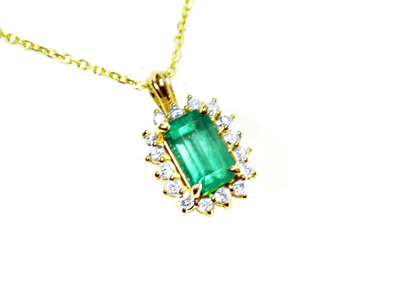 Gold necklace with a natural emerald and diamond accents on a topside view.