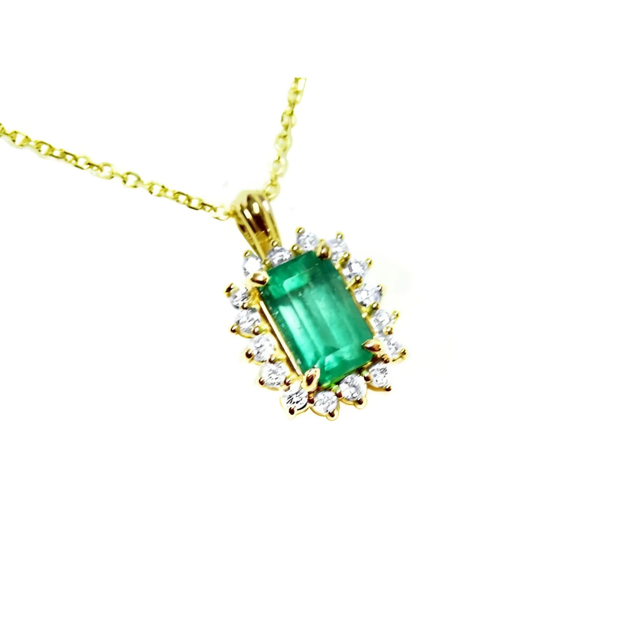 Gold necklace with a natural emerald and diamond accents on a topside view.