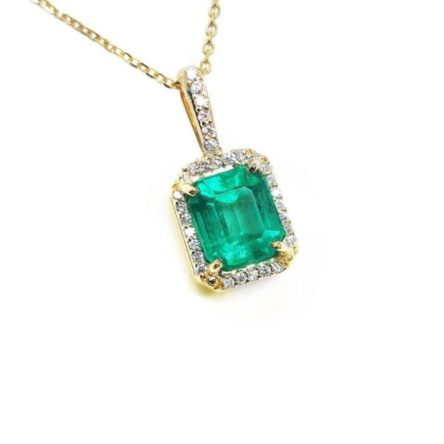14k yellow gold necklace with a natural colombian emerald pendant with a halo diamond.