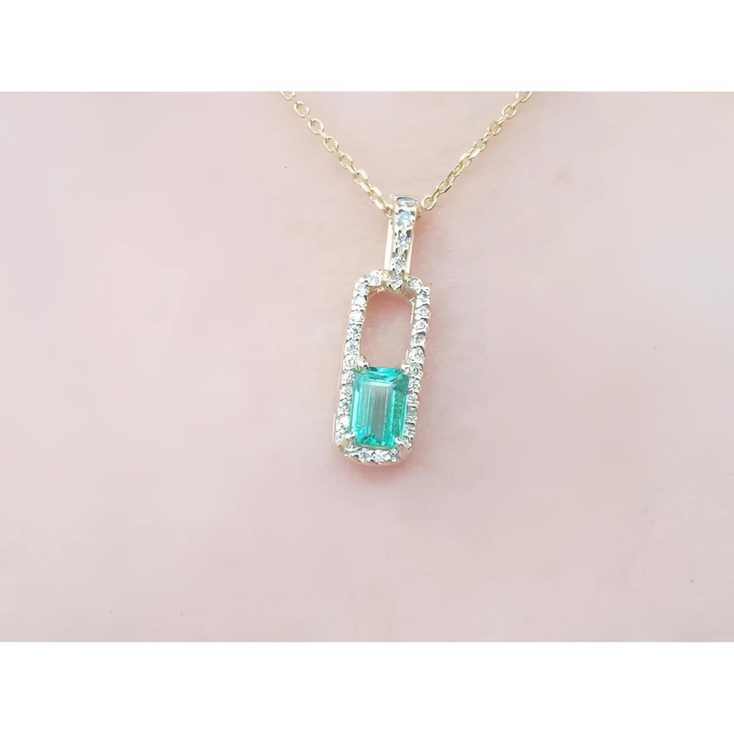 18K yellow gold emerald-cut emerald pendant with diamond halo on a delicate chain.