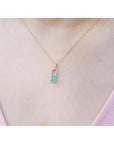 18K yellow gold emerald-cut emerald pendant with diamond halo on a delicate chain.