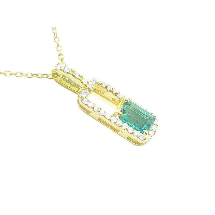 An emerald-cut Colombian emerald pendant with a halo of natural diamonds, handcrafted in 18K yellow gold.