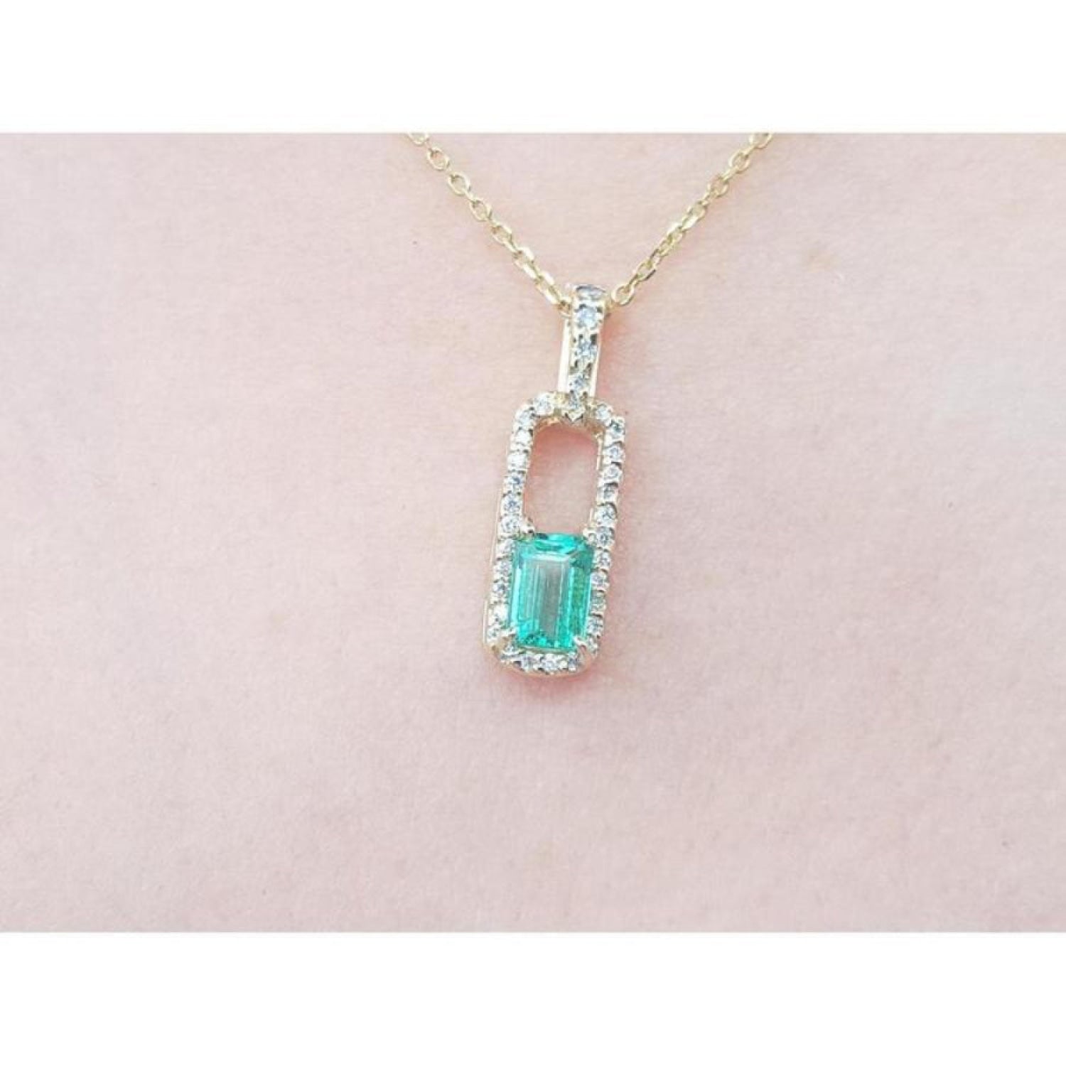 18K yellow gold emerald-cut emerald pendant with diamond halo on a delicate chain.