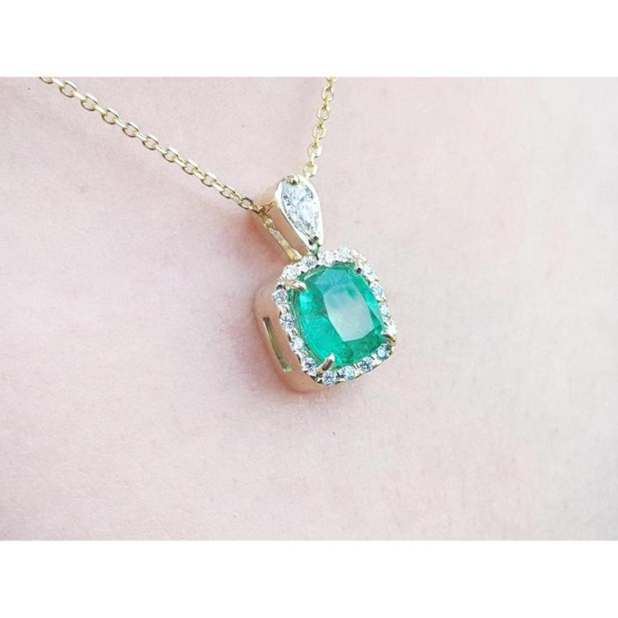 1.99 ct cushion-cut emerald halo pendant with natural diamonds on a 14K yellow gold chain.