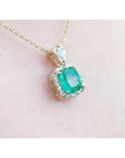 1.99 ct cushion-cut emerald halo pendant with natural diamonds on a 14K yellow gold chain.