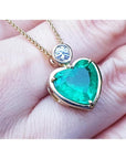 5.46 ct. heart-shaped emerald pendant in 18K yellow gold with a slider bail and bezel-set diamond.