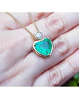 Heart-shaped emerald pendant in 18K yellow gold with a diamond slider bail on a delicate gold chain.