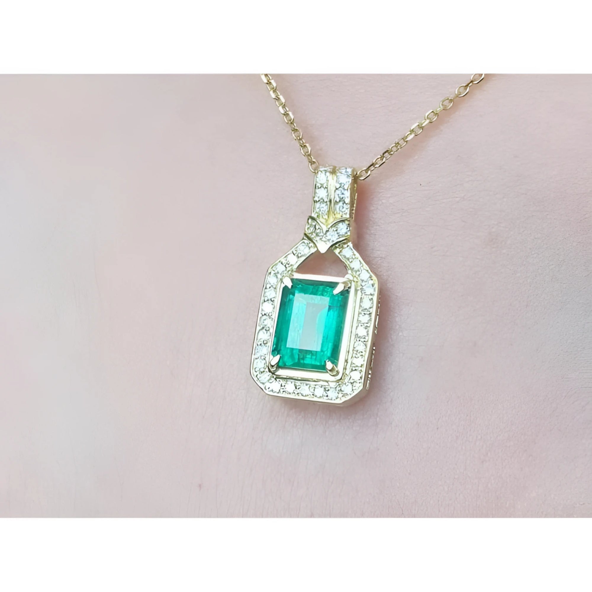 2.06 ct. emerald pendant with natural diamonds in 18K yellow gold, worn on a woman's neck.